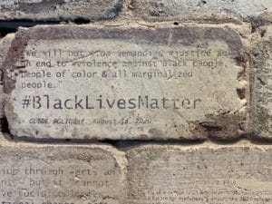 Close up of a brick that says "Black Lives Matter" on it.