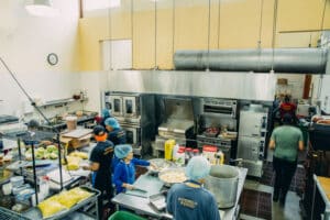 Looking from above into a commercial kitchen with chefs preparing food